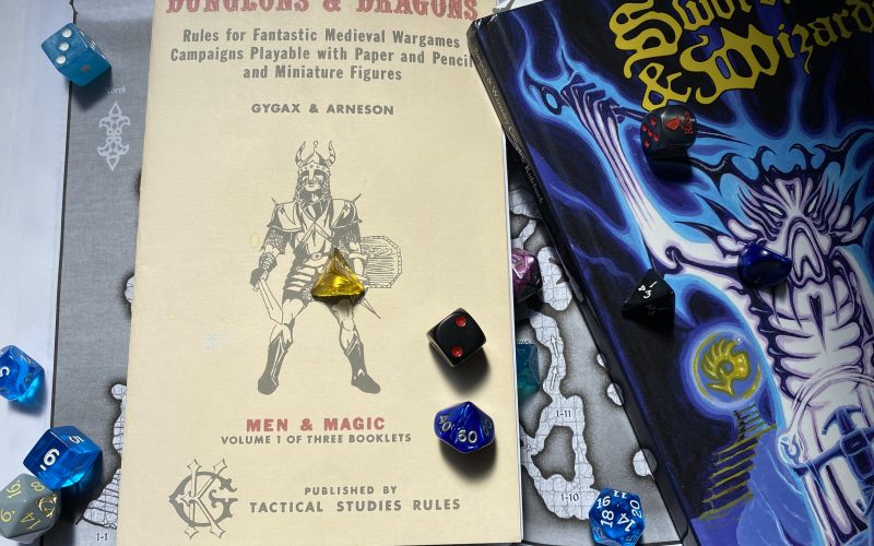 Scattered dice on game books used for the weekly Old School Dungeon Crawl